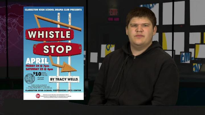 A student sitting right of frame with a poster displayed to the left titled, Whistle Stop, promoting the new play at the high school. 