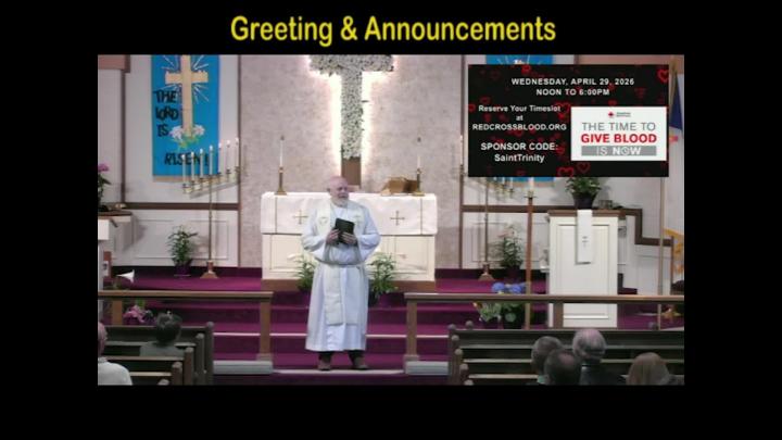 A pastor standing center frame with the text Greetings above written in yellow. 