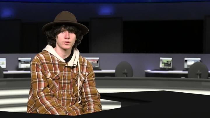 A student wearing a hat sitting at a virtual desk reading school announcements
