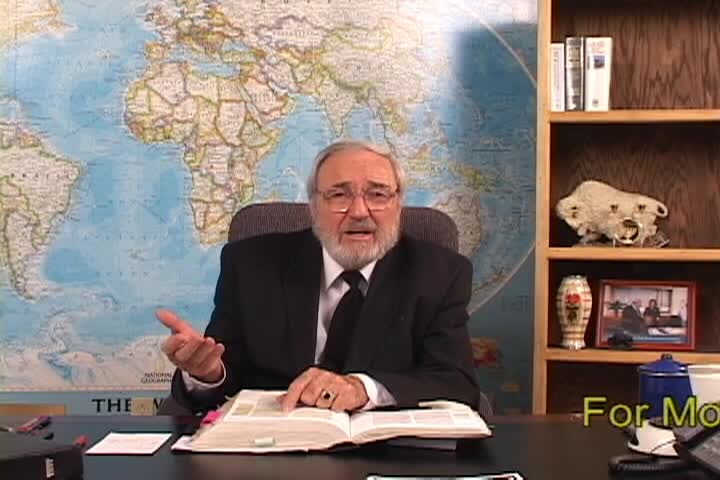 A man sitting center with an open book and a map behind him 